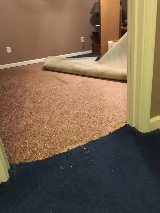 Carpet pad removal revealing water damage during Water Mitigation Services in Cumberland